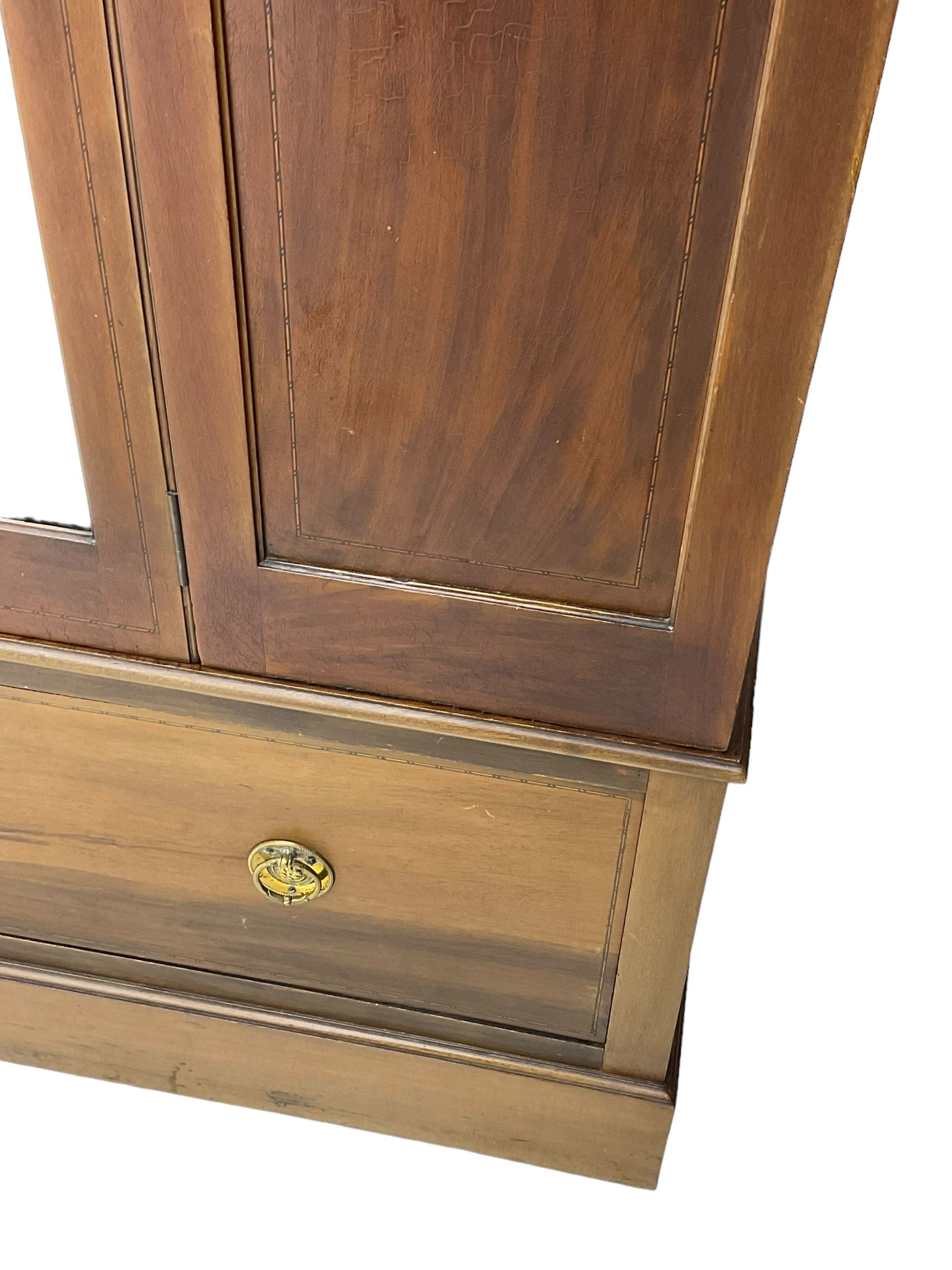 Edwardian inlaid mahogany wardrobe, projecting moulded cornice over central bevelled mirror glazed door, panelled uprights inlaid with trailing bellflowers and foliate decoration, the skirted base fitted with single drawer 