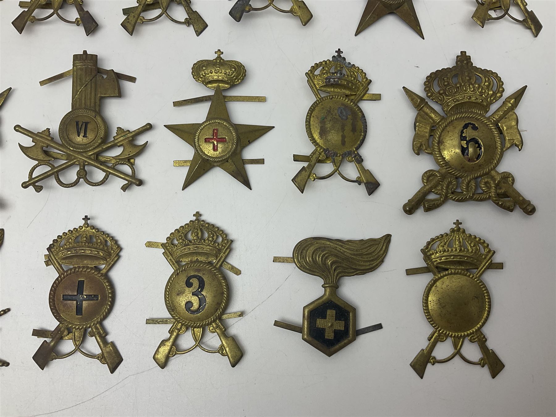Over thirty British and Continental military metal badges; together with quantity of shoulder titles, collar dogs, rank pips, uniform buttons etc