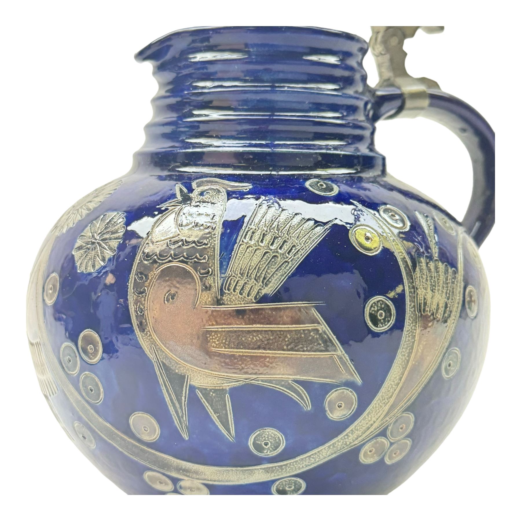 Wim Muhlendyck (1905-1986),  saltglaze stoneware jug of globular form with pulled and applied handle and ribbed neck with white cover, with stylised cockerels and flowers on a dark blue ground, with makers mark beneath, H22cm