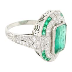Platinum emerald and diamond milgrain set dress ring, single octagonal cut emerald of 2.40 carat, surrounded by single cut diamonds and a border of calibre cut emeralds, with fancy pierced design gallery diamond and engraved flower head shoulders, stamped 850 Plat