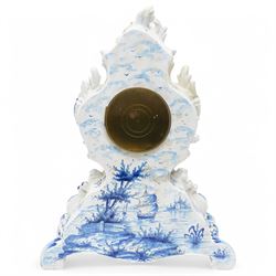 19th century delft blue and white Rococo style 8-day mantle clock, with a scrolling case and floral decoration, depiction of a courting couple in 18th century dress to the front and a contrasting scene of sailing ships on a lake to the rear, with a late 19th-century French twin train movement, enamel dial with Roman numerals, five minute Arabic's and gilt Louis XVI hands within a glazed cast bezel, with a rack striking movement sounding the hours and half-hours on a bell. No pendulum or key.  