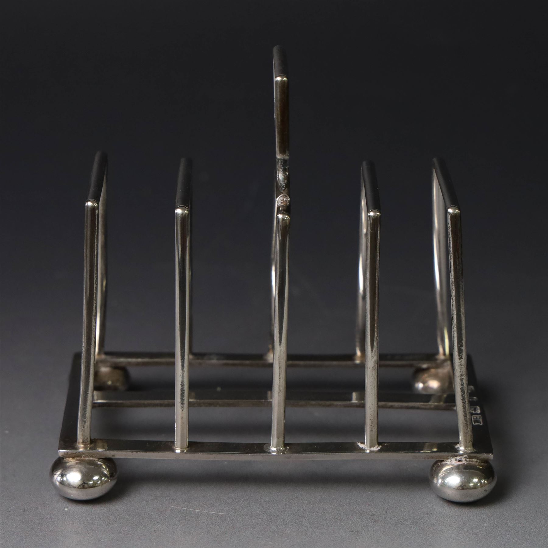 Victorian silver toast rack, with five angular bars and loop handle, upon four squat bun feet, hallmarked Thomas Hayes, Birmingham 1893, height including handle H10cm