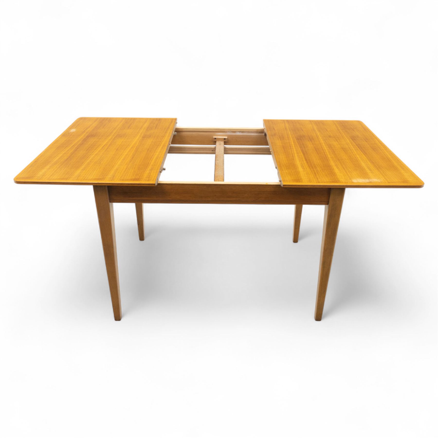 Gordon Russell - mid 20th century teak dining suite, comprising rectangular extending dining table and six matching chairs including one carver, each chair with padded upholstered seat and backrest in vinyl, on square supports, the table with plain top and rounded edges on tapered legs, an example of the firm’s functional post-war design with restrained modernist detailing (Chairs H 85cm, W 47cm, D 46cm) (Extends to 154cm)