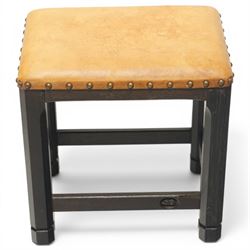 Acornman - dark stained oak stool with upholstered seat, rectangular top with tan leather seat with studded trim, raised on octagonal supports, with carved acorn signature, by the workshop of Alan Grainger of Brandsby