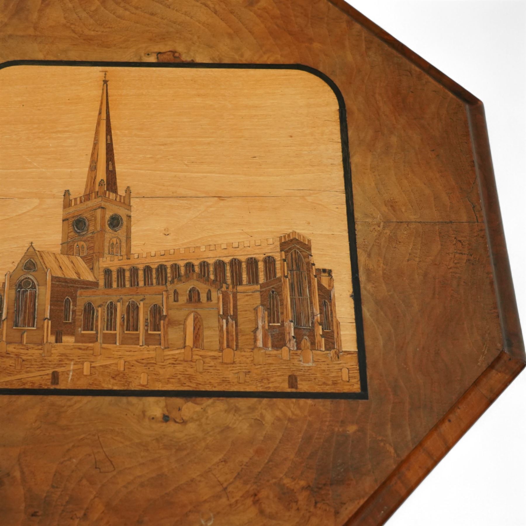 Victorian inlaid walnut occasional table, the octagonal top inlaid with a marquetry scene of Shakespeare's Church - The Holy Trinity at Stratford-Upon-Avon, over an ecclesiastical design frieze with turned finials and castellated form, raised on a spiral turned pedestal terminating to an acanthus carved tripod base with scroll feet, circa 1860
