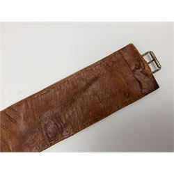 Late 19th century Yemeni Tuza jambiya as worn by religious elite, the 20.5cm curving blade with raised medial ridge, the horn hilt with pique style studwork, in a leather wrapped wooden scabbard with pierced metal mount and leather belt applied with embroidered 'gold' and 'silver' thread work panel; dagger L36cm overall, belt L84cm