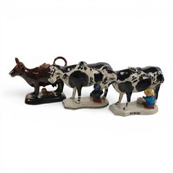 Three Staffordshire cow creamers, one with treacle glaze, the other two painted black and ...