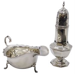 Early 20th century silver sauce boat, of typical form with flying scroll handle, upon three pad feet, hallmarked Barker Brothers, Chester 1915, including handle H7cm, together with an early 20th century silver sugar caster, of octagonal bellied form with pierced cover, hallmarked Mappin & Webb Ltd, Sheffield 1906, H16cm, total weight 7.18 ozt (223.6 grams)