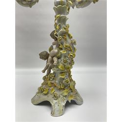 Dresden style candelabra, the central stem bordered by three branches, decorated with cherubs and yellow roses, H48cm
