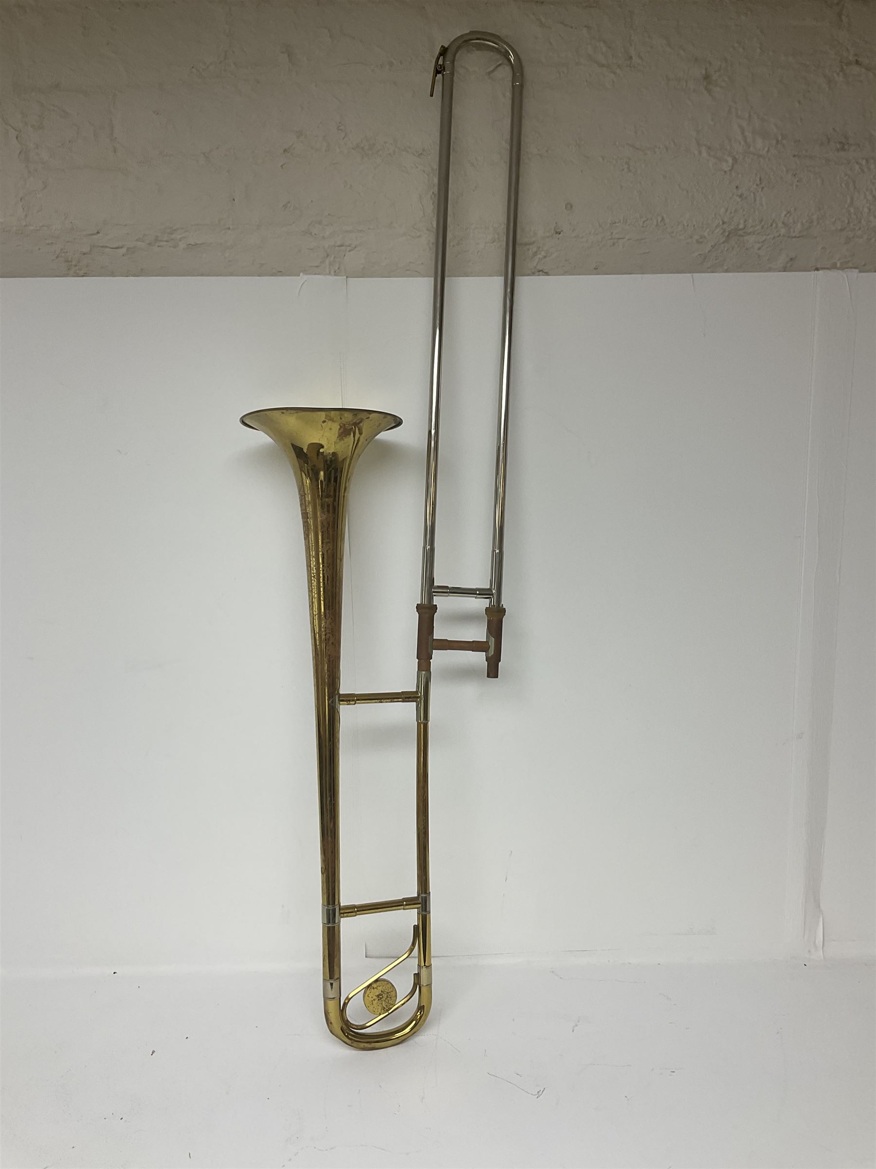 Three brass trombones comprising Elkhart Ind. USA 'CONN' model no.72H; Besson 'Concord'; and Selmer Distributed 'Lincoln'; two in carrying cases; and German B & M 'Champion' brass trumpet (4)