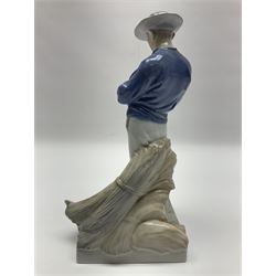 Two Royal Copenhagen figures, comprising Farmer with scythe, no 685 and Girl and calf, no 779, both with impressed and printed marks beneath, largest H26cm