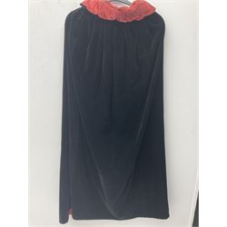 Full length 1930's childs black velvet cape, with ruched collar and red velvet lining, with a single button neck fastening 