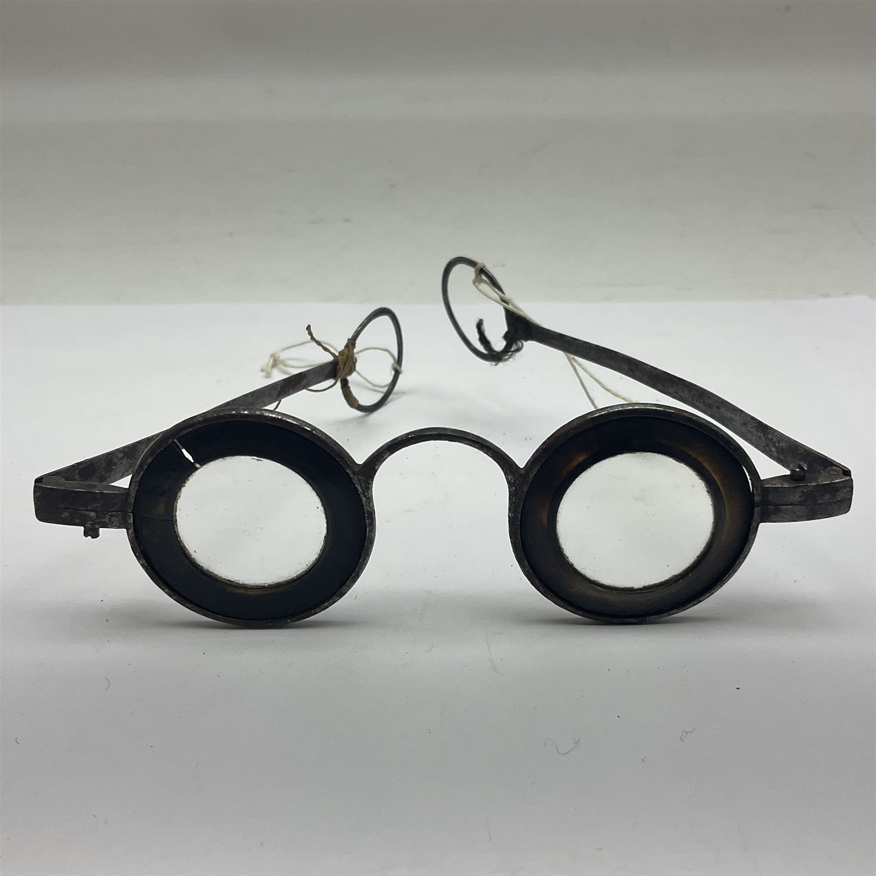 Pair of 18th century horn and steel rimmed spectacles, arm L10.5cm, rim D3.5cm