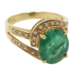 Gold oval emerald ring with diamond swirl surround and shank, stamped 14K
