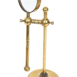 Early 20th century lacquered brass table top adjustable magnifying glass, with pivoting lens upon a circular weighted base, H26cm