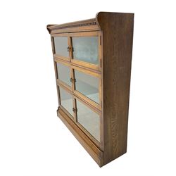 Early 20th century oak three heights library bookcase, enclosed by three sets of double glazed doors, on moulded skirt base