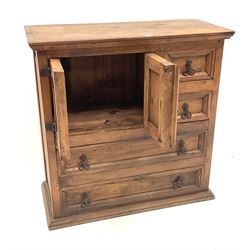 Pine chest, two short drawers flanked by two cupboard doors above two long drawers, platform base 