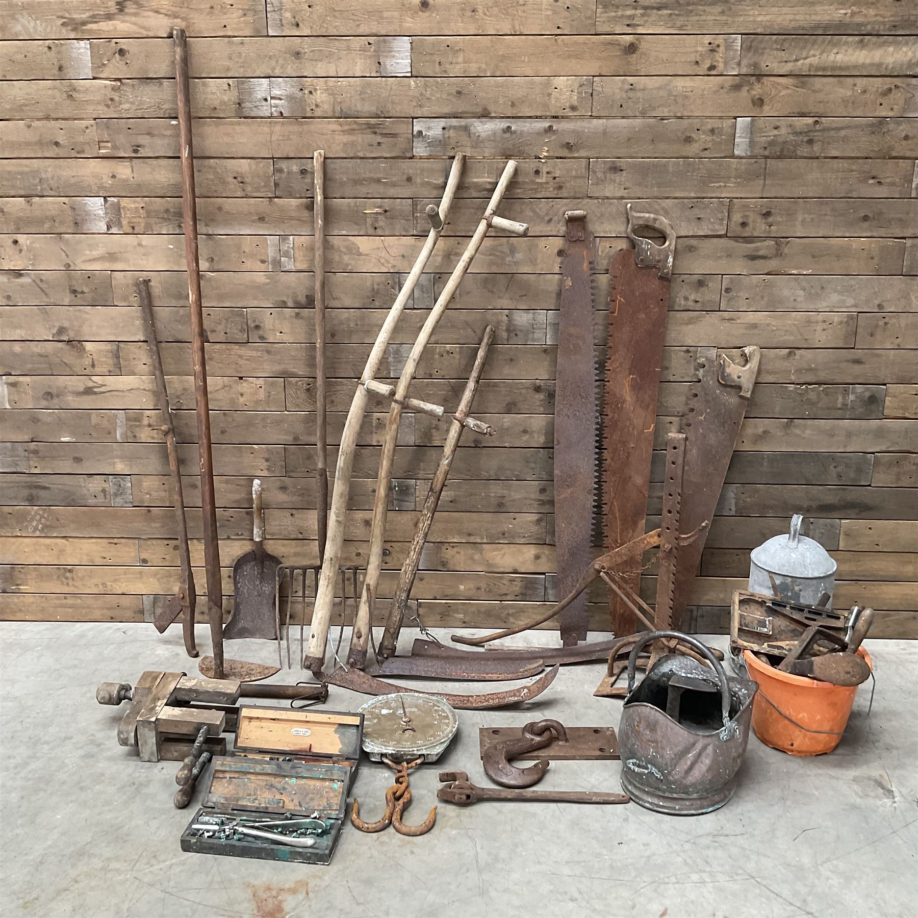 Large quantity of vintage hand tools including scales, scythes, saws etc
