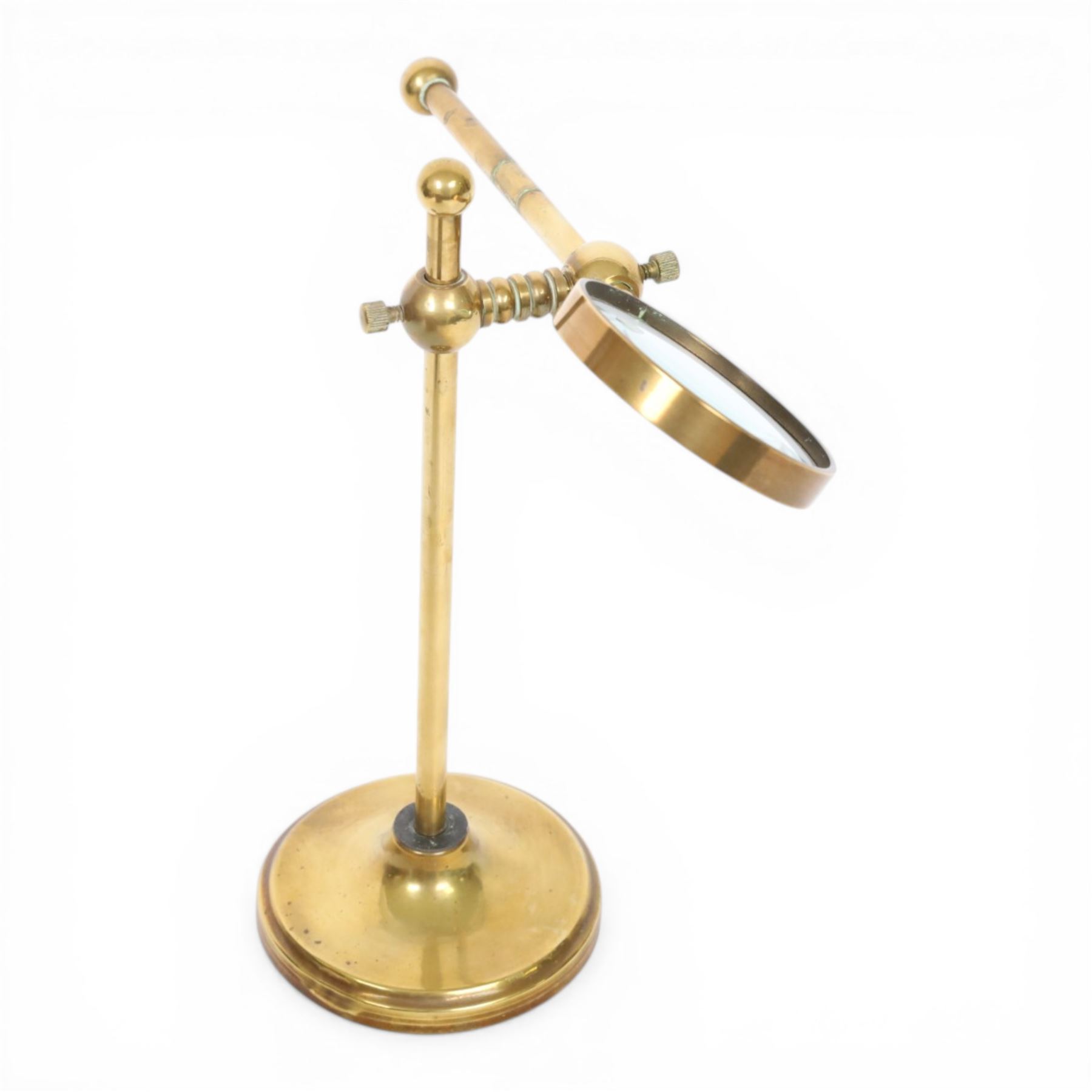 Early 20th century lacquered brass table top adjustable magnifying glass, with pivoting lens upon a circular weighted base, H26cm