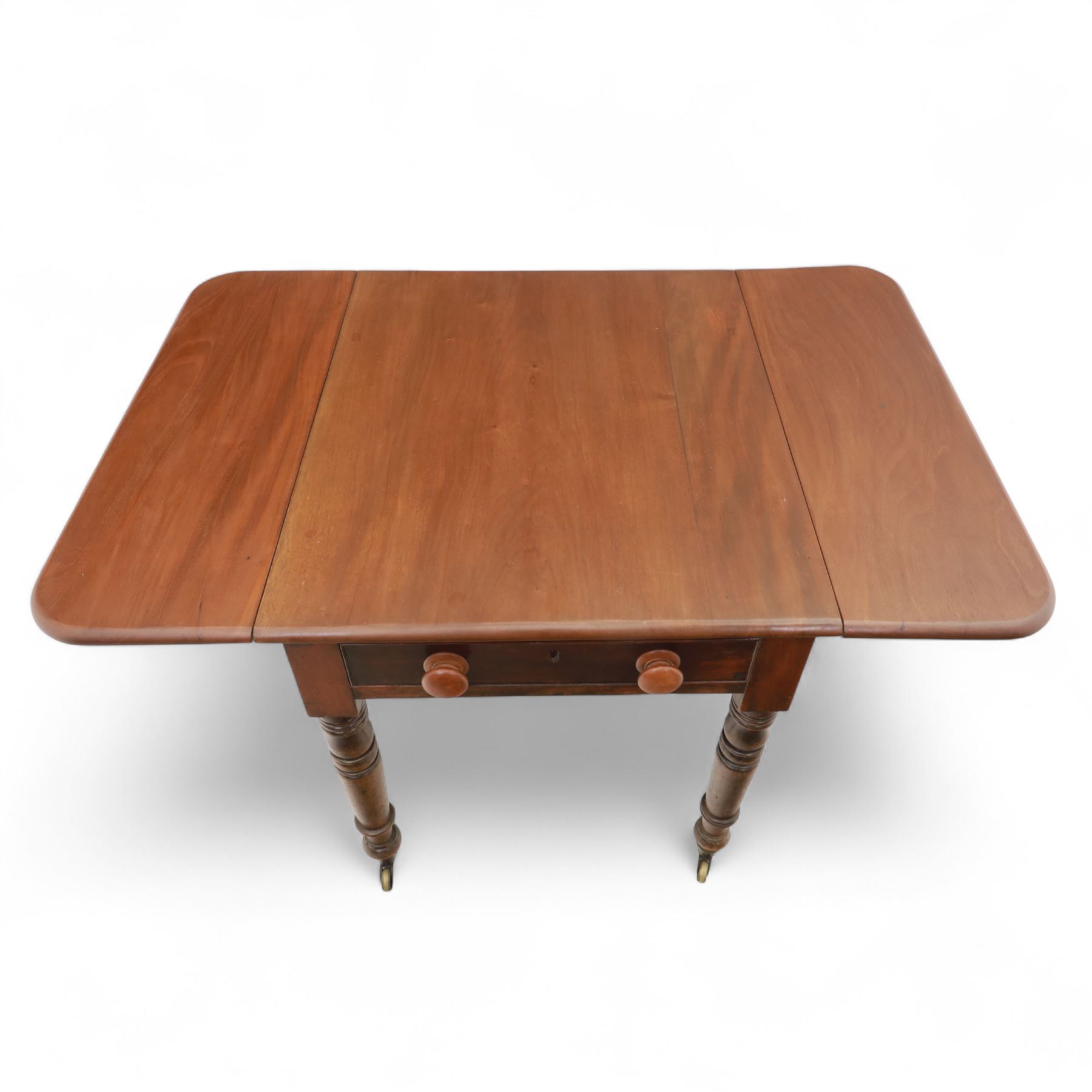 Mahogany drop-leaf Pembroke table circa 1900, with rounded rectangular top and single frieze drawer, raised on turned and tapered supports with brass castors (Extended 128cm)