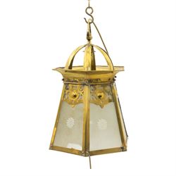 Arts & Crafts brass hall lantern, circa 1900, of hexagonal tapering form with open dome top support and pierced foliate detail above frosted glass panels with flower head detail, H41.5cm D29cm