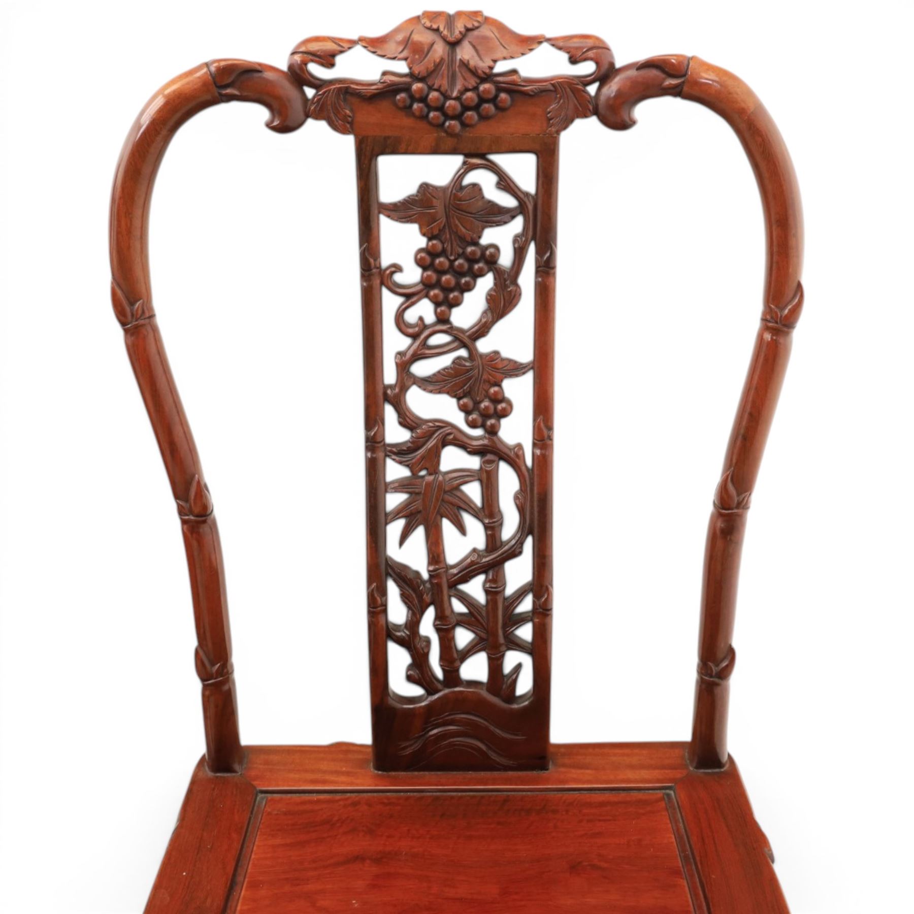 20th century Chinese ornately hardwood dining table and chairs, circular table with 'Lazy Susan' top with pierced carved frieze, raised on a quadriform base with carved foliate detail, the chairs en suite with carved pierced detailing  