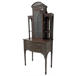 Early 20th century mahogany cabinet on stand, with pierced arched foliate pediment over blind-fretwork frieze, fitted with single astragal glazed door flanked by bevelled mirror back shelves with cluster column uprights, serpentine base fitted with two drawers with blind-fretwork facias 