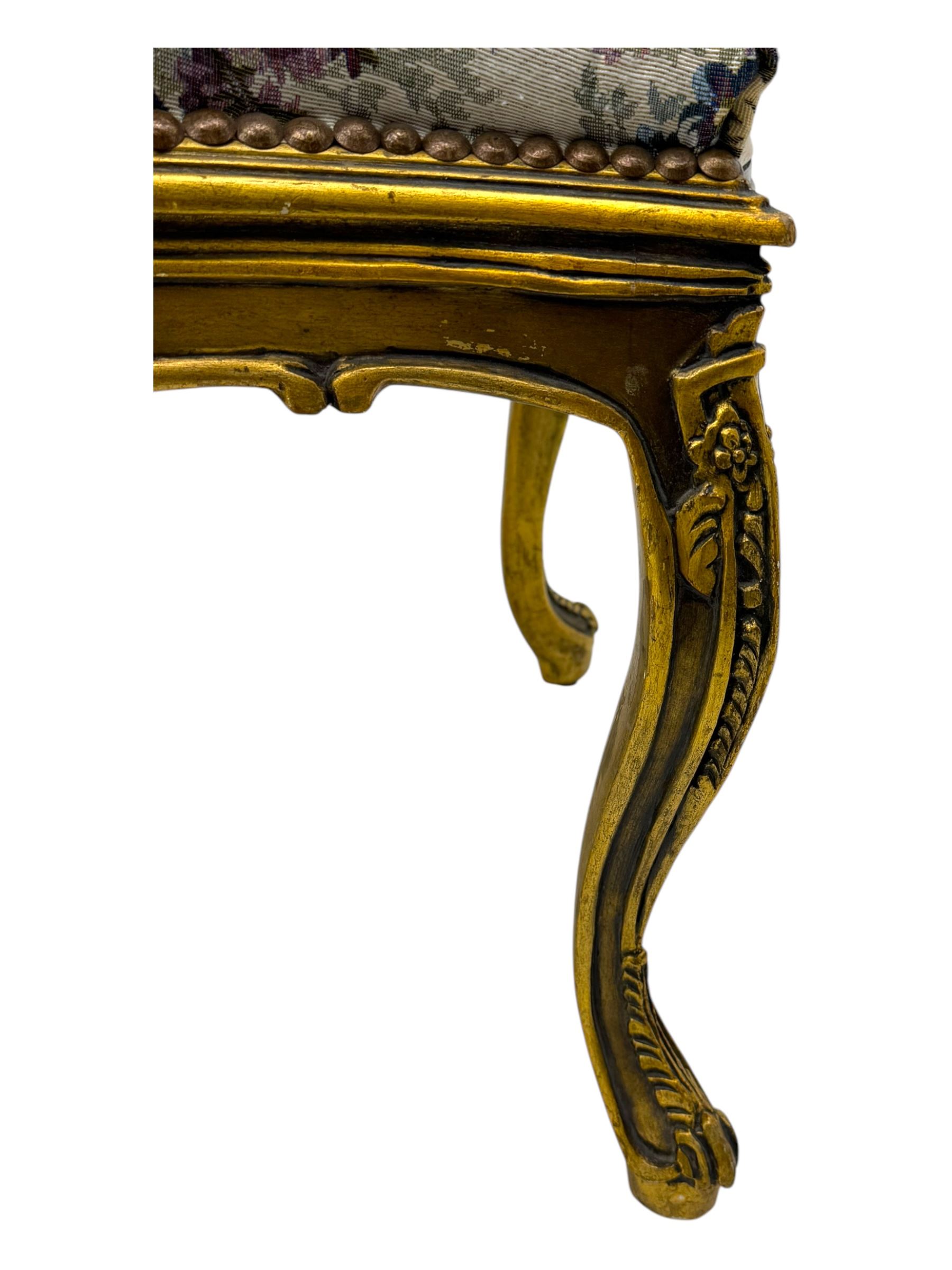 Pair of Louis XV-design giltwood stools, each upholstered in floral tapestry fabric, the carved frame adorned with scrolling foliage and shell motifs, raised on cabriole supports