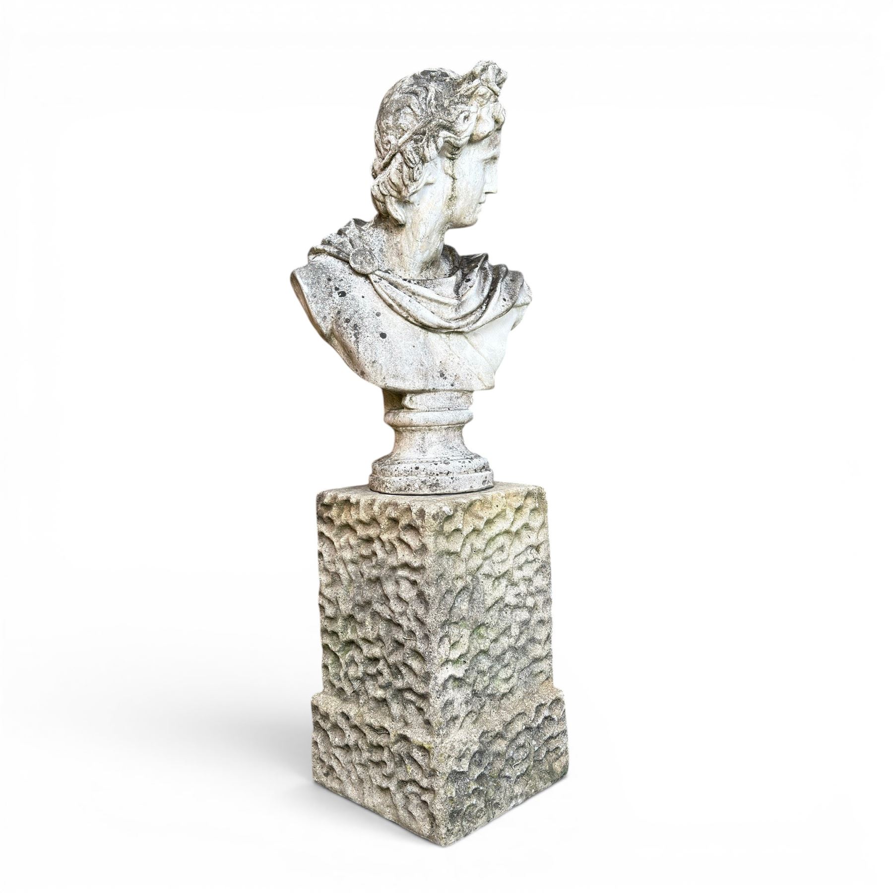 Roman Neoclassical style cast stone bust, weathered finish, raised on textured stone plinth of tapering form