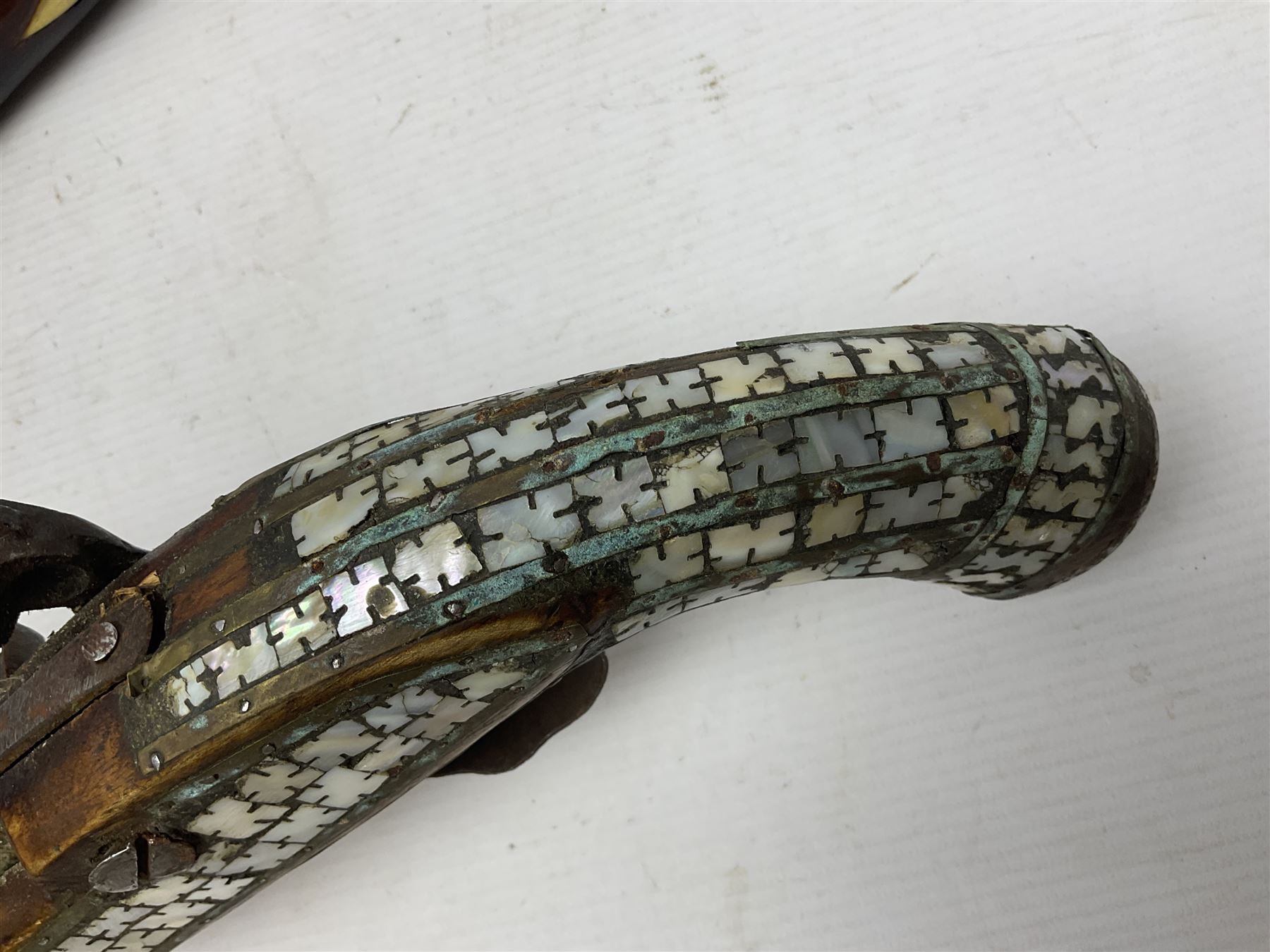 Modern non-firing reproduction Tower flintlock pistol marked with crowned GR and Tower to the lock, brass skull crusher butt and fittings L40cm overall; another Indian/Moorish reproduction flintlock pistol with mother-of-pearl inlay; and a modern die-cast replica Colt style revolver (3)