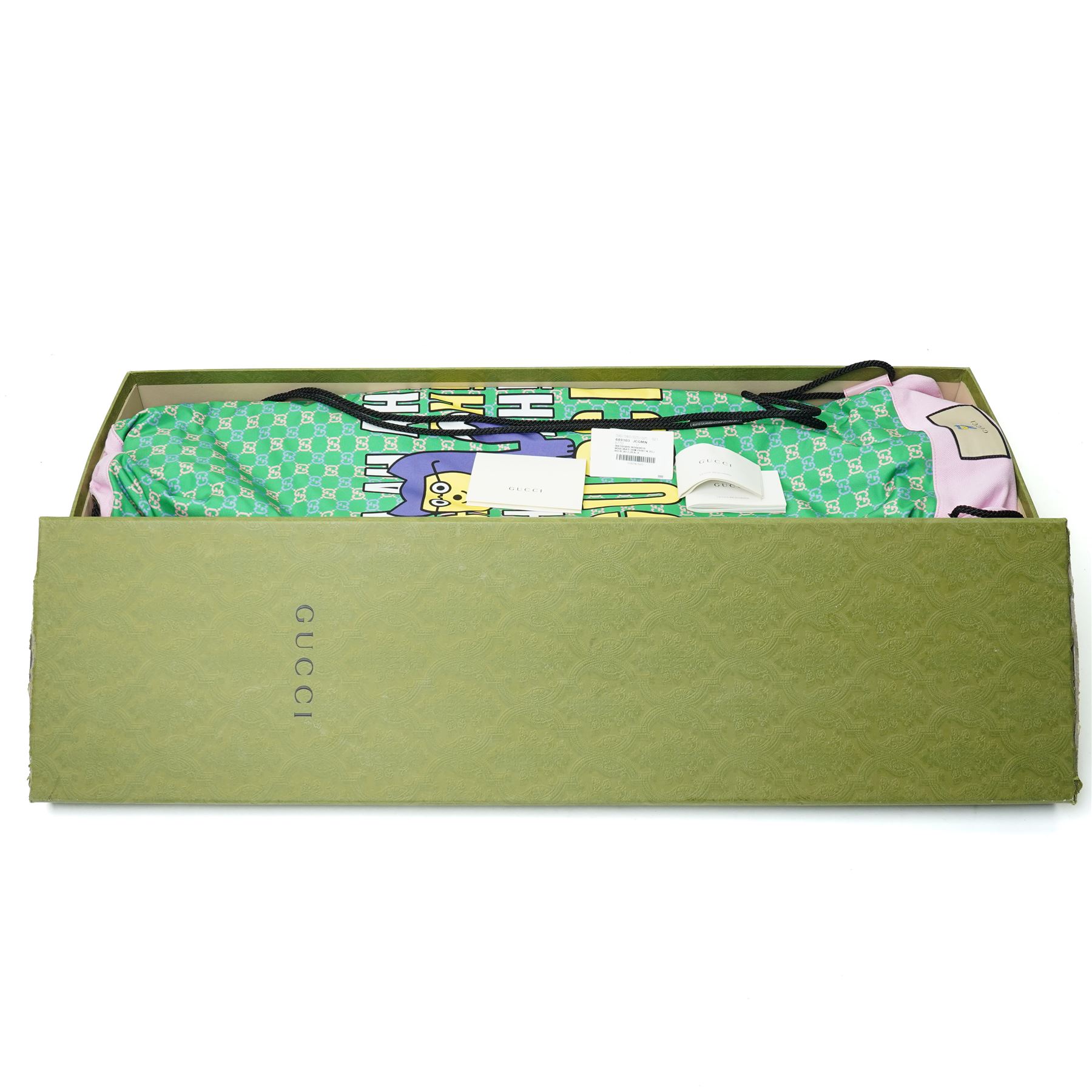 Gucci x Palace skateboard, Spring/Summer 2021, green GG monogram wood deck with multicolour ‘AH AH AH! GUCCI’ lettering and cartoon character mascot motif, fitted with Gucci-branded metal trucks and red and cream wheels, model no. 689103 JCGMN, presented with original GG monogram drawstring dust bag, protective sleeve, outer box and accompanying cards, Skateboard L81cm W20cm