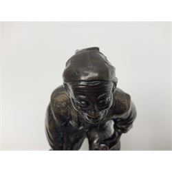 Oriental bronze figure of a gentleman, modelled seated upon barrel with a pipe in one hand and a flask in the other, H21cm