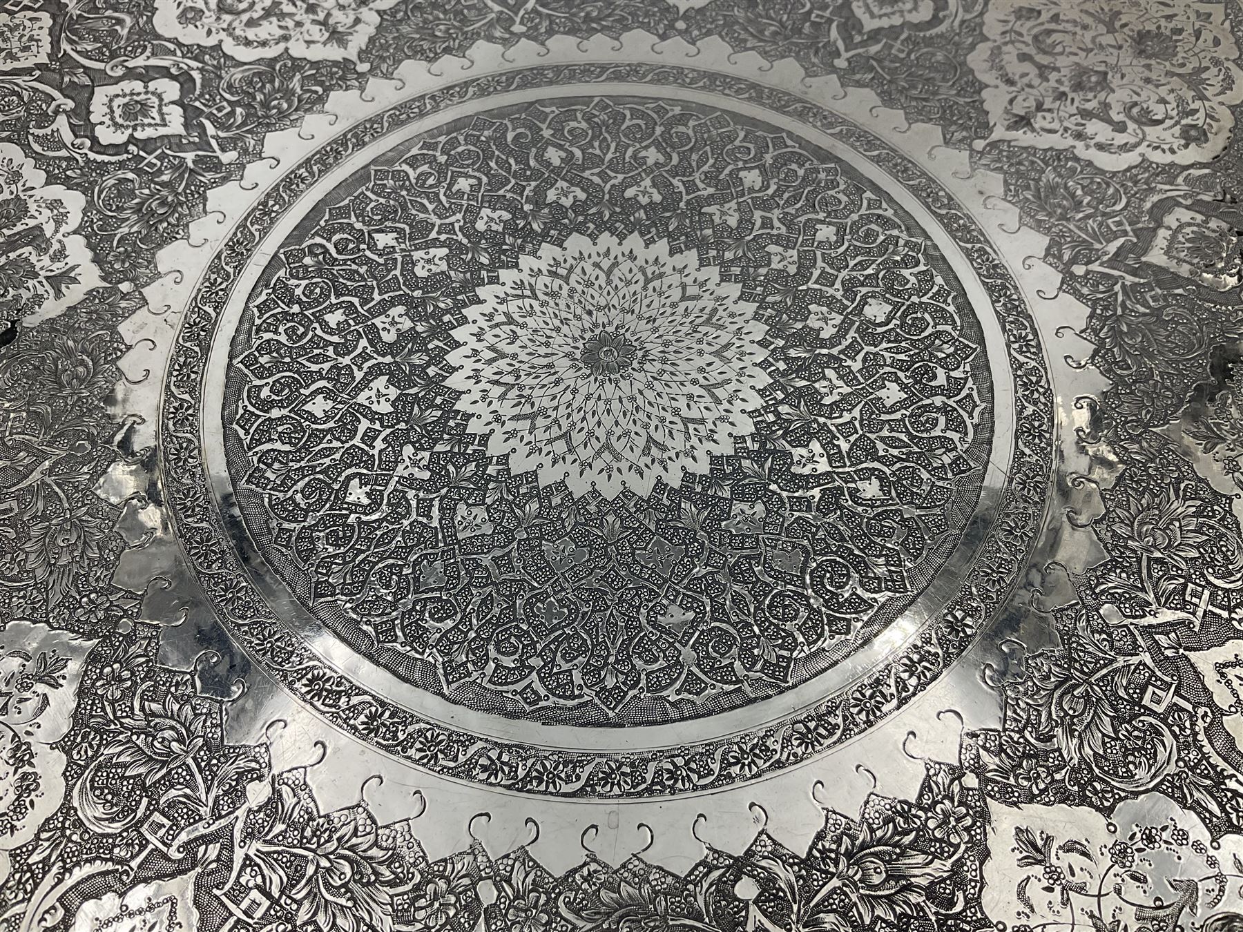 Early/mid 20th century Persian silver tea service, comprising circular serving tray, teapot, twin handled sucrier and cover, milk jug, five tea glasses with six silver holders, six tea spoons, and pair of sugar tongs, each profusely chased with foliate arabesque decoration, each bearing marks including 84 for 840 fineness, tray D40cm, teapot H16cm