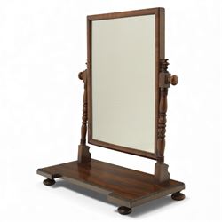 Two early 20th century mahogany swing dressing mirrors, comprising one with arched rectangular plate in a moulded frame on shaped supports, flanked by two inlaid trinket drawers (H 69cm, W 88cm, D 20cm), together with another rectangular plate mirror on turned supports upon bun feet (H 58cm, W 48cm, D 23cm)