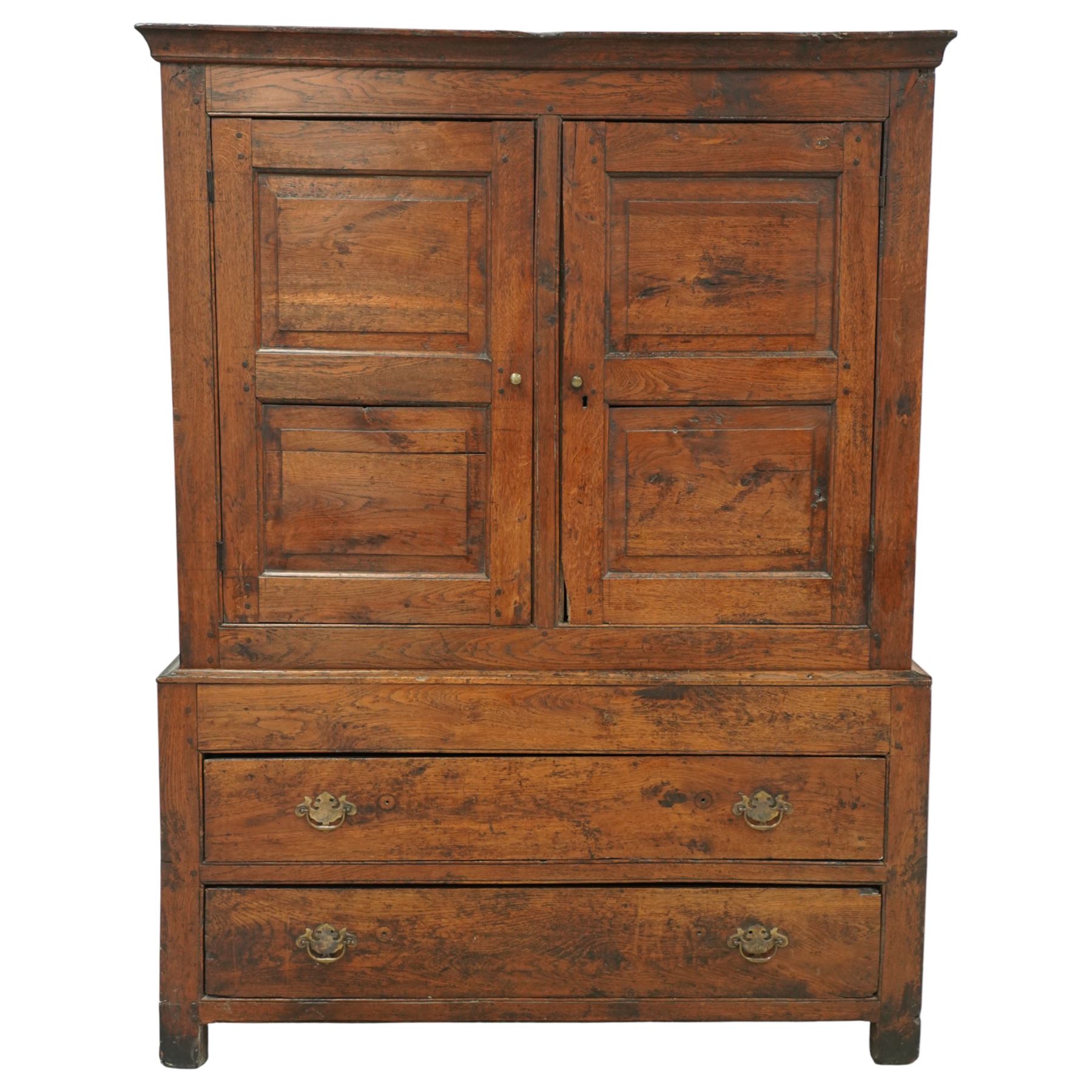 Georgian rustic oak housekeeper’s cupboard, moulded cornice above a pair of fielded panel cupboard doors enclosing a boarded interior with central divider and hanging hooks, the base fitted with two long drawers with brass swan neck handles, raised on stile supports