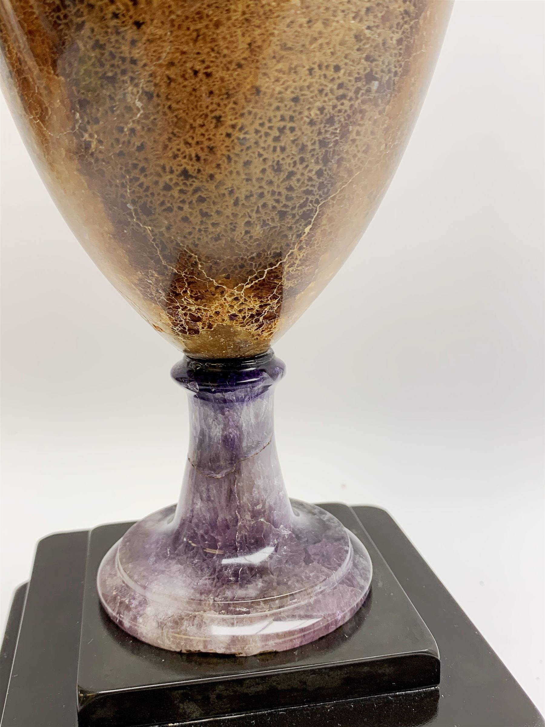 Early 19th century and later Blue John urn, Winnats one vein, of ovoid form with integrated cover and ball finial, upon a spreading circular base, and square stepped black lacquered base, H34.5cm