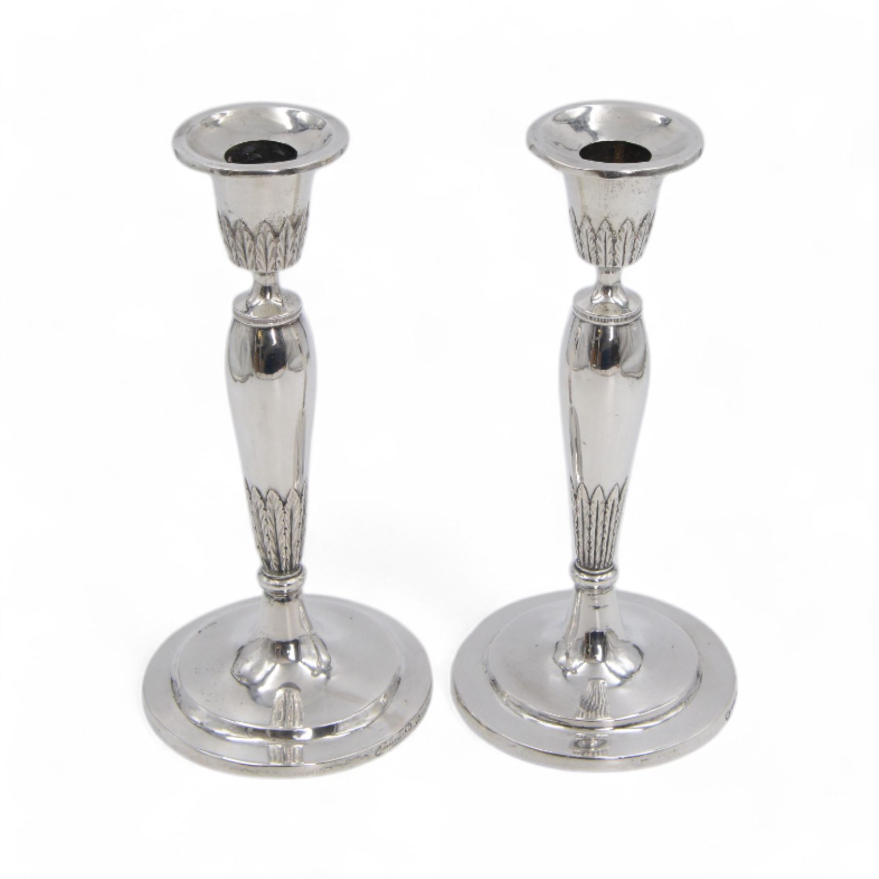 Pair of continental silver candlesticks, probably German Hanau, each of tapering form, with fern leaf decoration, upon a stepped circular base, with Hanau marks and assay scrape to base, H19cm