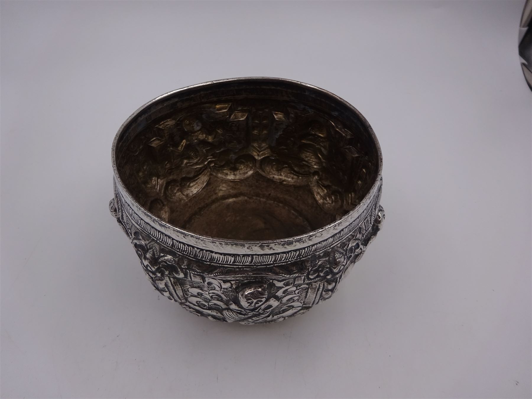 Burmese silver bowl, embossed with figural panels, C scrolls and floral decoration, H8.5cm