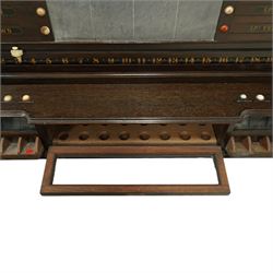 Victorian wall-mounted oak and walnut cased scoreboard,  moulded top, with a name stencilled in the frieze ‘J. Ashcroft, Victoria Street, Liverpool’, the board with chalk panel in the centre for recording scores, sliding panels on both sides for the various games of Billiards and Snooker, two numbered rotating arms with adjustable sliding score keepers, the base section with 5 apertures on each side, and coloured ivory roundels, all with glass front for viewing the tokens inside, with drawers beneath, the centre has a long glass panel for storing billiard balls, circa 1870 This item has been registered for sale under section 10 of the APHA Ivory Act Reference UNEGEBLB
