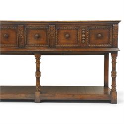 Titchmarsh & Goodwin - Tudor oak dresser base, three drawers flanked by foliate carving and carved wooden knobs, on turned and carved supports, united by a full length undertier