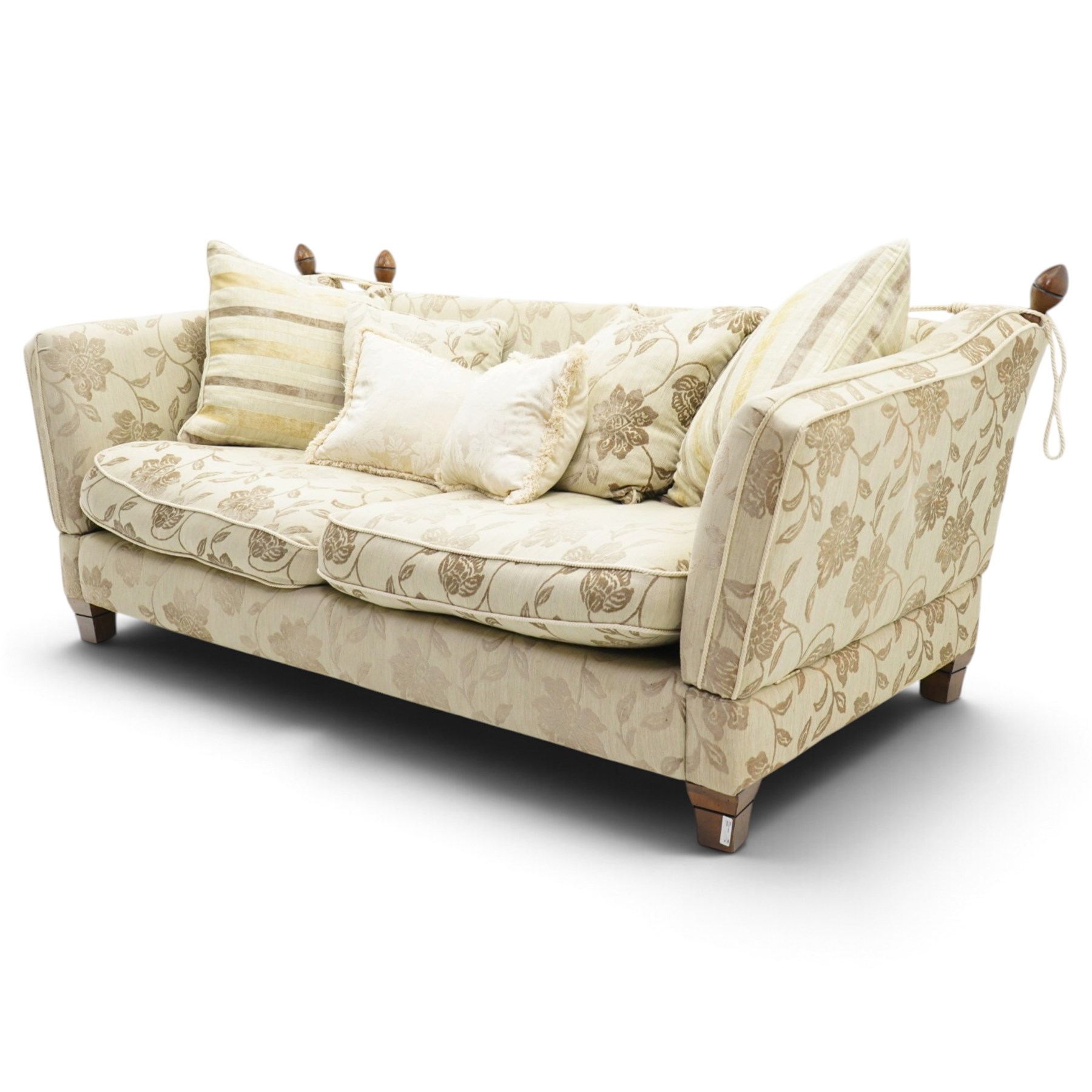 Traditional knoll sofa, upholstered in cream and olive floral fabric, adjustable drop ends secured by cords to turned finials, loose seat and back cushions with piped edges, on square tapering feet, with four scatter cushions