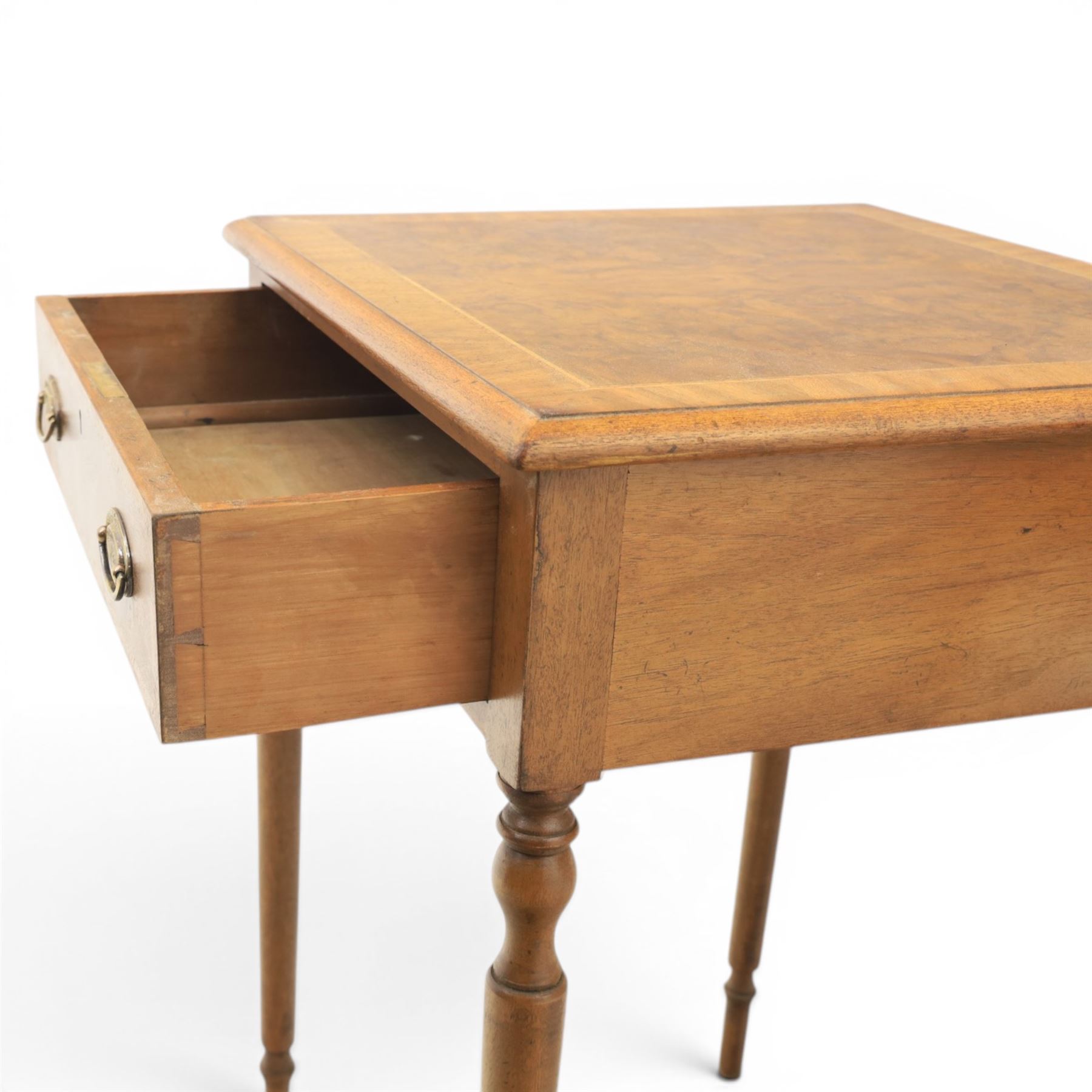Traditional design pair of walnut lamp tables, figured top with crossbanded edge, above a single frieze drawer with brass oval handles, raised on turned supports
