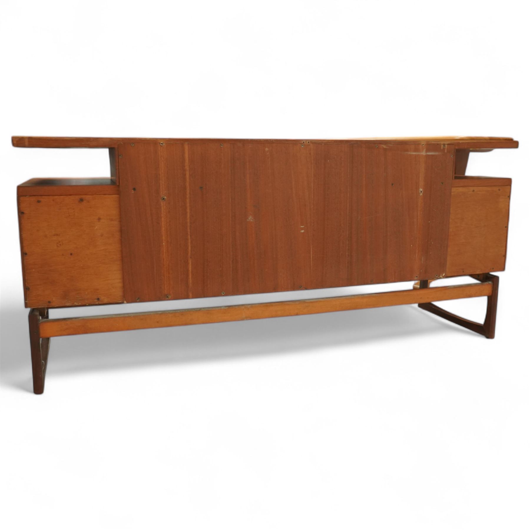 R Bennett for G Plan - mid-20th century teak 'Quadrille' desk or dressing table,  shaped platform rectangular top above rectilinear open base above four drawers with sculpted handles, on rectangular frame supports 