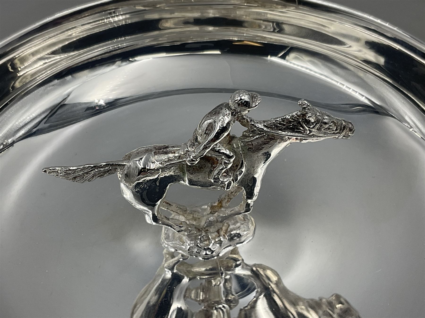Spanish silver coin dish, with white metal chain rim and upon three ball feet, together with a silver plated armada style dish, with cast racehorse and jockey to centre, coin dish D4.8cm, armada dish D20.5cm