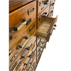 Early 20th century three sectional haberdashery shop fitting drawers, fitted with twenty-four drawers, on turned and reeded supports with castors 
