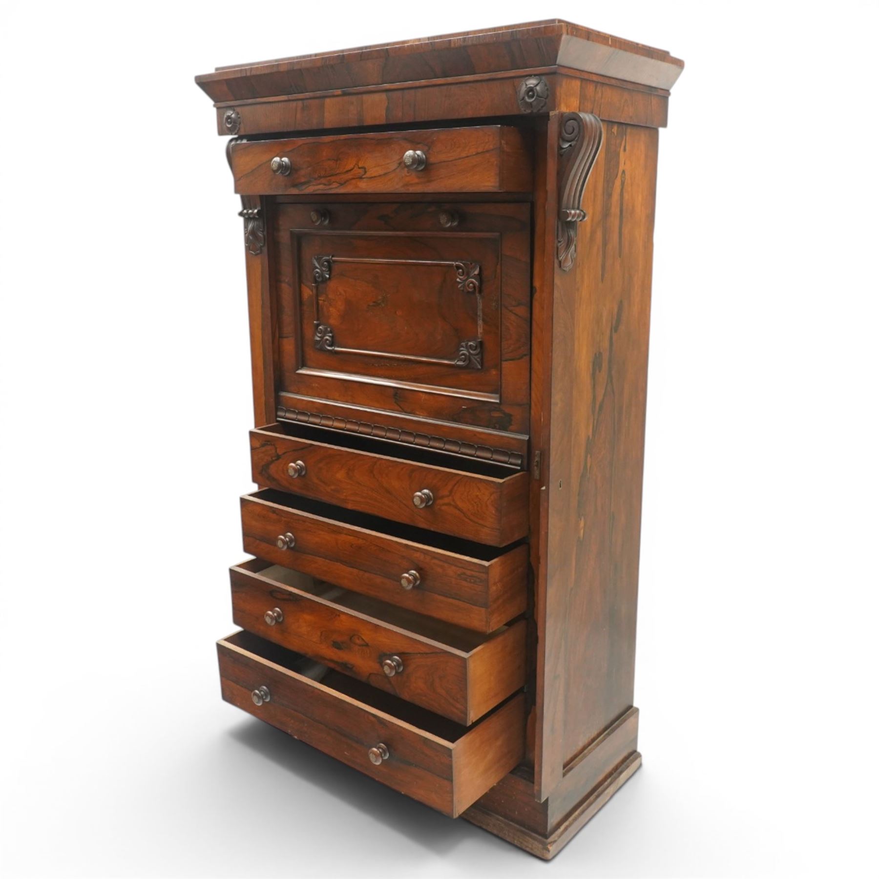 Victorian rosewood Wellington secretaire chest, the projecting stepped cornice over a banded frieze with moulded rosette mounts, single drawer over a secretaire fall-front opening to reveal a maple lined interior with assorted pigeonholes and correspondence drawers, over a lappet carved lower edge with four graduating drawers below, each with turned pull handles, flanked by hinged lock to the right and plain stile to the left surmounted by reeded corbels, raised on a skirted base
