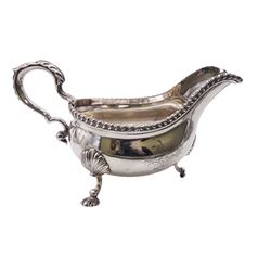 Set of three George III silver sauce boats, each of typical form with gadrooned rim, and acanthus capped scroll handle, upon three shell mounted shell pad feet, one example with engraved crest to body, hallmarked George Methuen, London 1760 including handle H13cm, approximate total weight 44.73 ozt (1391.5 grams)