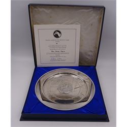 Modern limited edition silver salver, celebrating the achievements of Grundy, champion racehorse of 1975, each of circular form with gadrooned rim and plaque to centre depicting jockey mounted upon Grundy, designed by Stuart Devlin, limited edition no. 15/500, hallmarked London 1976, makers mark LH, D23cm, within silver lined fitted box and limited edition certificate 