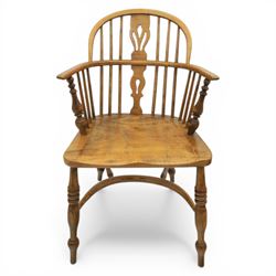 Late 20th century elm and beech low back country Windsor armchair, the arched hoop back with central pierced splat and turned spindles, shaped arm rail on turned supports, saddle seat, raised on turned legs united by a crinoline stretcher