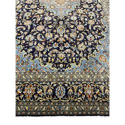 Persian Kashan indigo ground carpet, floral pattern light blue ground central medallion and spandrels, the fielding decorated with interlacing leafy branches and palmettes, the repeating floral pattern border enclosed within guard stripes
